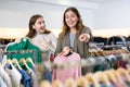 Happy girls pointing finger at new clothes in clothing store Royalty Free Stock Photo