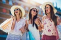 Young girls walking the street with shopping bags. Happy shopping with smiles Royalty Free Stock Photo