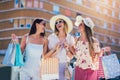 Young girls walking the street with shopping bags. Happy shopping with smiles Royalty Free Stock Photo