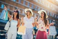 Young girls walking the street with shopping bags. Happy shopping with smiles Royalty Free Stock Photo