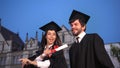 Happy young graduates dancing and celebrating graduation in park Royalty Free Stock Photo