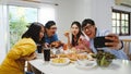 Happy young group having lunch at home. Asia family party eating pizza food and making selfie with her friends at birthday party