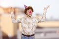 Happy young guy with clown nose fooling around making funny faces. Royalty Free Stock Photo