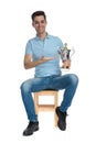 Happy young guy presenting his trophy and smiling Royalty Free Stock Photo