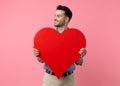 Happy young guy smiling and holding big red heart Royalty Free Stock Photo