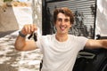 Happy young guy standing by black car, showing key Royalty Free Stock Photo