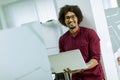 Happy young African American IT specialist wearing glasses working on his laptop in the office Royalty Free Stock Photo