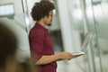 Happy young African American IT specialist wearing glasses working on his laptop in the office Royalty Free Stock Photo