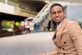 Happy young handsome African businessman thinking in the city outdoors Royalty Free Stock Photo