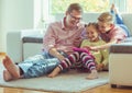 Happy young handsome father having fun with his two cute children playing with tablet Royalty Free Stock Photo