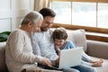 Joyful intergenerational family enjoying laptop app indoors. Royalty Free Stock Photo