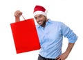 Happy young handsome man wearing santa hat holding red shopping bag Royalty Free Stock Photo