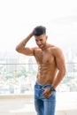 Happy young handsome muscular Persian man shirtless against view the city Royalty Free Stock Photo