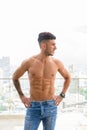 Happy young handsome muscular Persian man shirtless against view the city Royalty Free Stock Photo