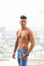 Happy young handsome muscular Persian man smiling shirtless against view the city Royalty Free Stock Photo