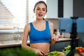 Happy young healthy woman influencer preparing fresh salad