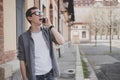 Happy young hipster man walking on the street and talking on phone Royalty Free Stock Photo