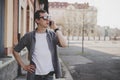 Happy young hipster man walking on the street and talking on phone, with copy space Royalty Free Stock Photo