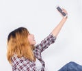 Happy young hipster woman taking selfie photo on smartphone over white background Royalty Free Stock Photo