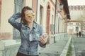 Happy young hipster woman walking on the street, using her smartphone Royalty Free Stock Photo