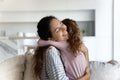 Happy Latin mom and daughter hug at home