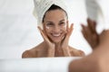 Happy young hispanic woman applying cream.