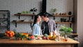 Happy young housewife and carefree young guy standing kissing in their kitchen. A beautiful young couple of lovers in a