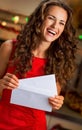 Happy young housewife with christmas letter in kitch Royalty Free Stock Photo