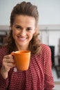 Happy young housewife drinking tea in kitchen Royalty Free Stock Photo