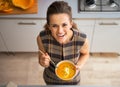 Happy young housewife eating pumpkin soup Royalty Free Stock Photo