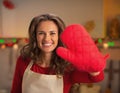 Happy young housewife showing red kitchen glove Royalty Free Stock Photo