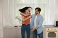 Happy young husband spin wife in funny dance at kitchen