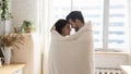 Loving couple wrapped in cover having romantic moment at home Royalty Free Stock Photo