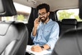 Happy young indian businessman talking over phone, sitting in taxi Royalty Free Stock Photo