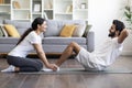 Happy young indian couple exercising at home together, doing sit-ups Royalty Free Stock Photo