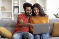 Young Indian Couple With Laptop Booking Vacation Online While Relaxing At Home Royalty Free Stock Photo