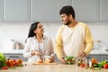 Happy young indian couple preparing healthy vegetarian food at home Royalty Free Stock Photo