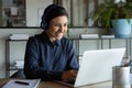 Happy young indian ethnicity female manager in headphones working remotely. Royalty Free Stock Photo