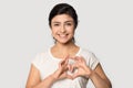 Happy young indian ethnicity woman making heart shape gesture symbol.
