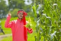 happy young Indian farmer showing corn fruit at field Royalty Free Stock Photo