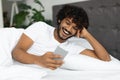 Happy young indian man chatting with girlfriend in bed Royalty Free Stock Photo