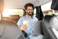 Happy young indian man entrepreneur working on laptop in taxi Royalty Free Stock Photo