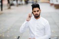 Happy young indian man talking on his cellphone in the city with fixed bicycle Royalty Free Stock Photo