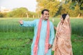 Happy young indian rural farmer couple in agricultural field looking at each other Royalty Free Stock Photo