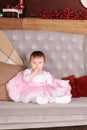 Happy young infant girl sitting in big chair