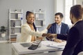 Happy young interracial couple shake hand of male bank manager broker Royalty Free Stock Photo