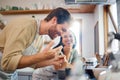 Happy young interracial couple standing by the stove while cooking together in the kitchen at home. Young caucasian man Royalty Free Stock Photo