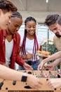 happy young interracial students playing table soccer, at barbecue outdoor party Royalty Free Stock Photo