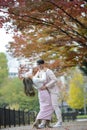 Happy young japanese couple under autumn trees Royalty Free Stock Photo