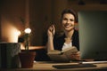 Happy young lady designer using computer and holding book Royalty Free Stock Photo